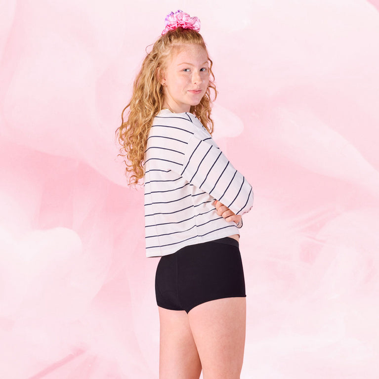 Teen girl modeling Teens Boxer Heavy underwear, smiling subtly.