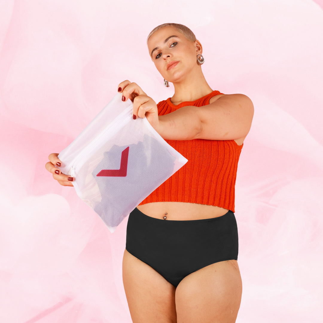 Woman holds a Bodyform® Laundry Bag designed for washing delicate garments, featuring a zipper and mesh material to protect and preserve fabric quality.
