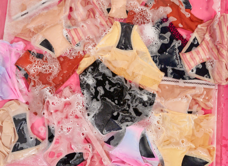 Colorful underwear with soap suds on a pink background