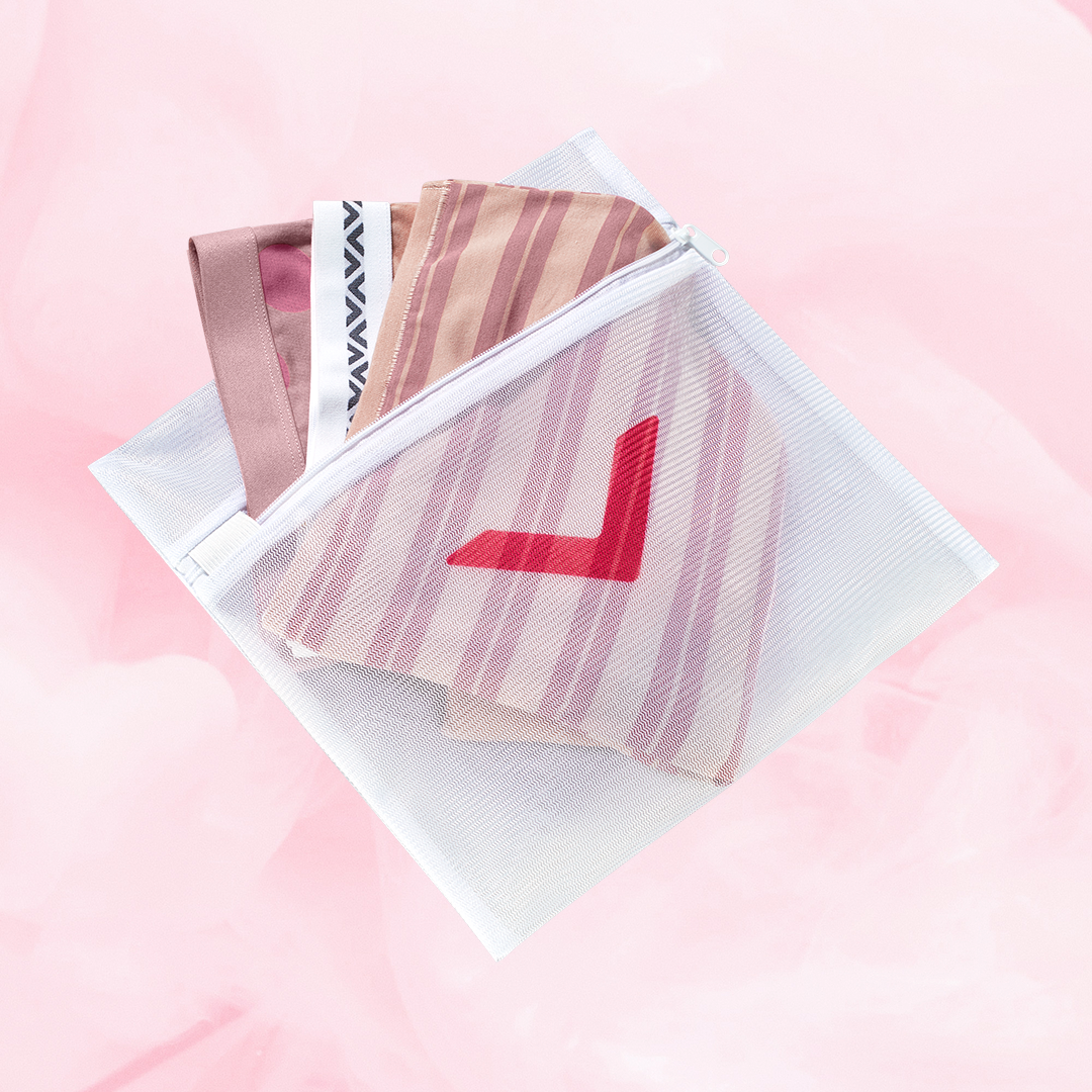 White mesh Laundry Bag with a red arrow design, designed to protect delicates in the wash. Features zipper closure to securely hold items.