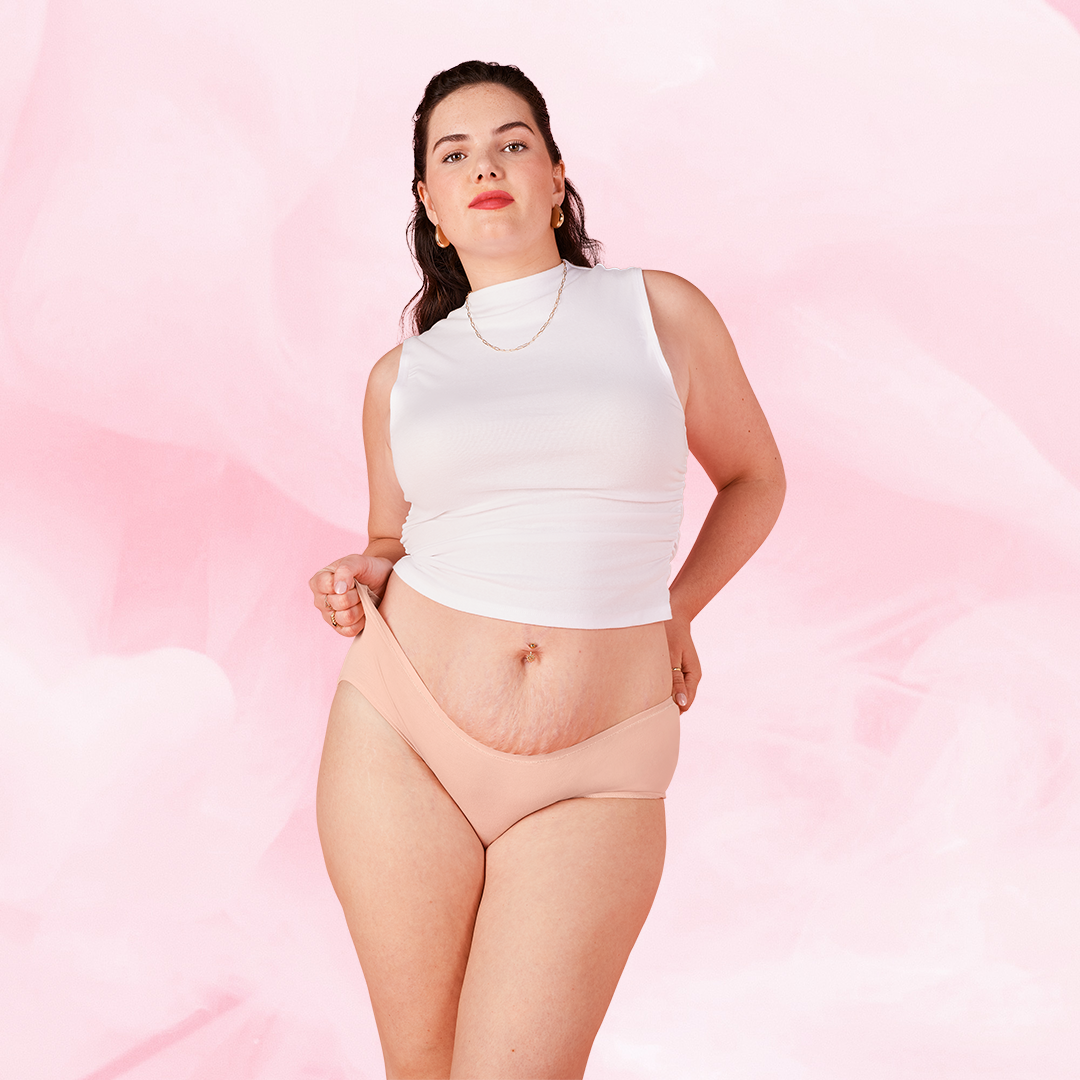 Woman modeling ComfortFit Essentials Hipster Heavy period pants, showcasing the slimline edges and soft, breathable fabric designed for comfort and reliable protection.
